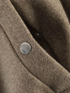 Loose-fit jacket in neutral tone with turtleneck collar and defining sash belt