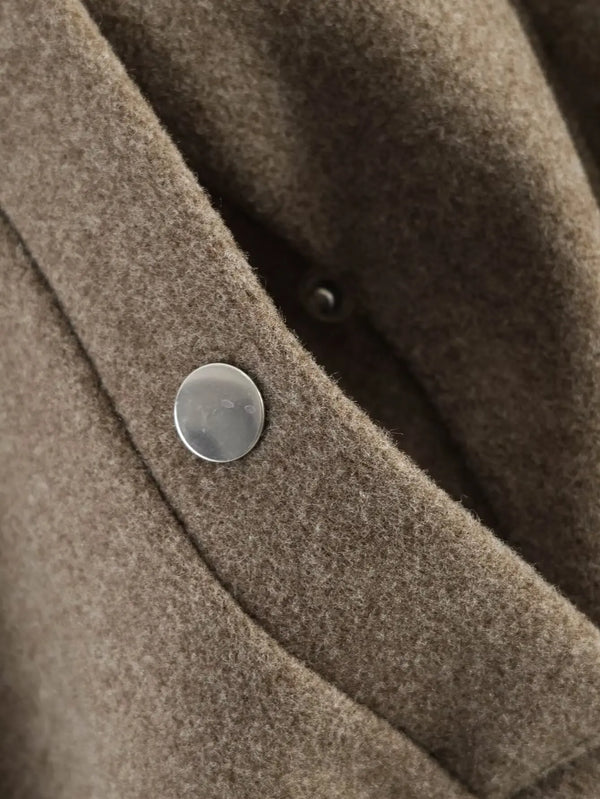 Loose-fit jacket in neutral tone with turtleneck collar and defining sash belt